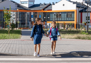 To jenter på skoleveien hånd i hånd.