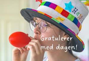 Gutt med gøyal hatt på blåser opp en ballong.