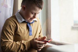 Gutt bruker rmobiletelefonen og ser glad ut.
